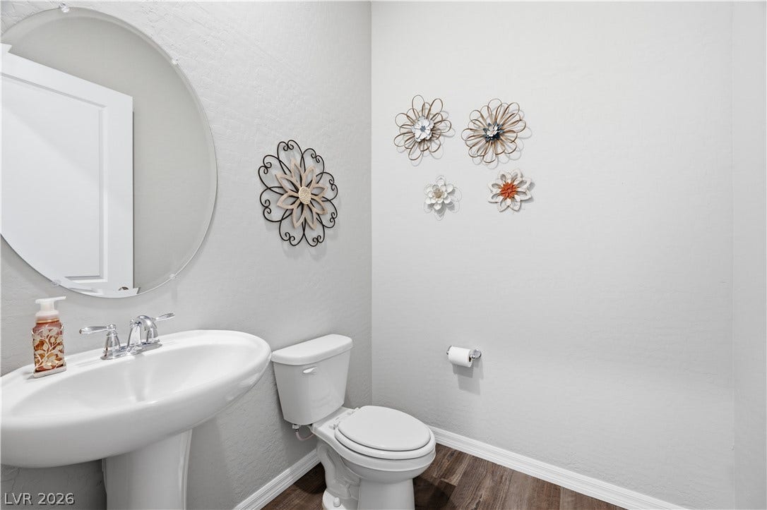 51 Thorn Creek Street, Henderson, NV 89011 Smooth plaster walls and rich wood-texture flooring define this contemporary powder room.