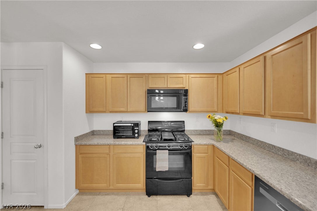 Ample wooden cabinetry and durable stone counters define this functional culinary space.