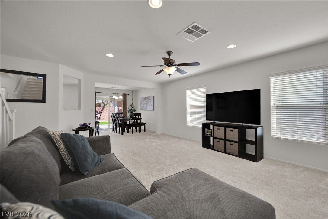 Plentiful natural light and soft carpeting define this open living area.