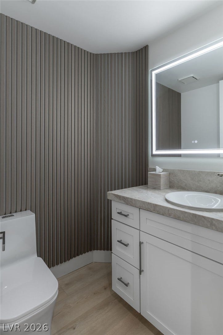 8633 Robinson Ridge Drive, Las Vegas, NV 89117 Textured wall paneling pairs with a stone-counter vanity in this modern powder room.