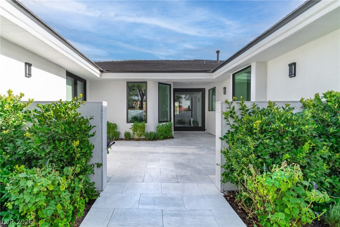 8633 Robinson Ridge Drive, Las Vegas, NV 89117 Sleek architectural lines frame a stone-paved entry courtyard flanked by manicured green hedges.