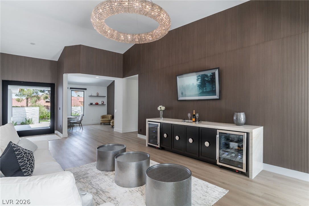 8633 Robinson Ridge Drive, Las Vegas, NV 89117 Vaulted ceilings and wall paneling frame this modern living space with light wood floors.