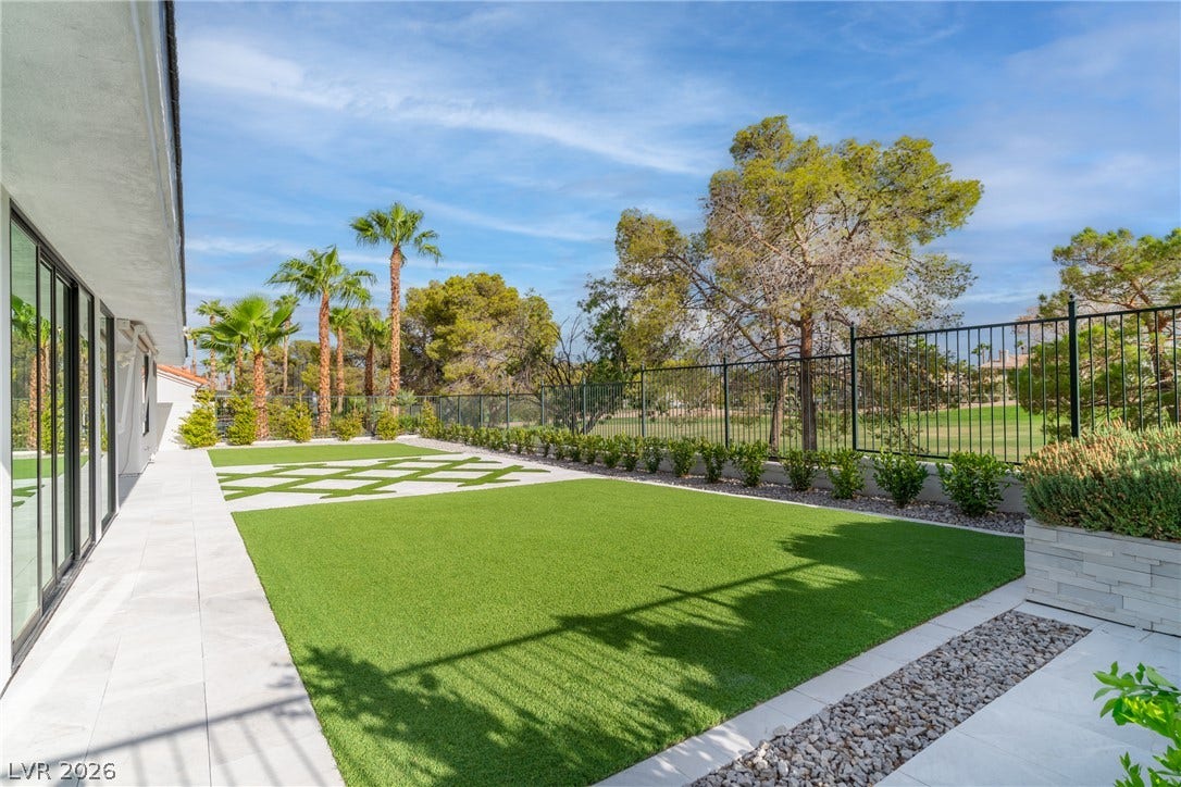 8633 Robinson Ridge Drive, Las Vegas, NV 89117 Manicured turf and modern hardscaping border a secure metal fence overlooking the golf course.