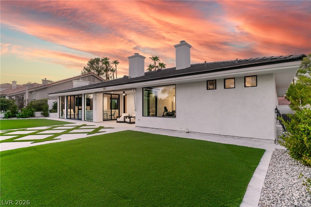 8633 Robinson Ridge Drive, Las Vegas, NV 89117 Manicured lawns and smooth stone pavers flank this modern stucco exterior beneath dramatic sunset skies.
