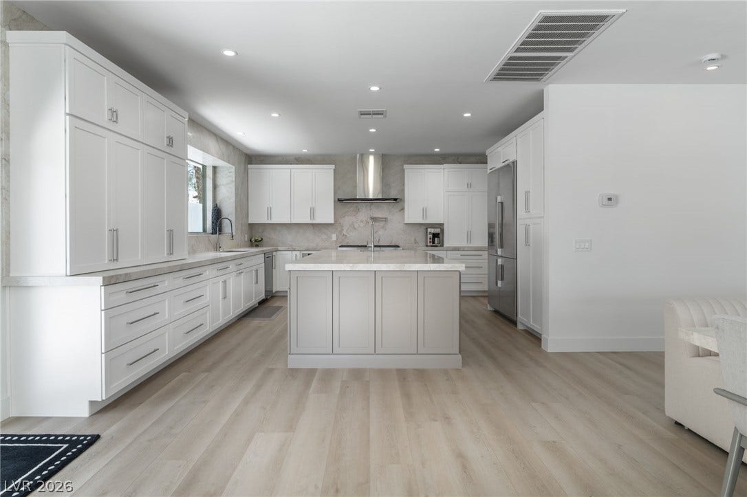 8633 Robinson Ridge Drive, Las Vegas, NV 89117 Gleaming stone countertops and a spacious central island anchor this light-filled modern kitchen.