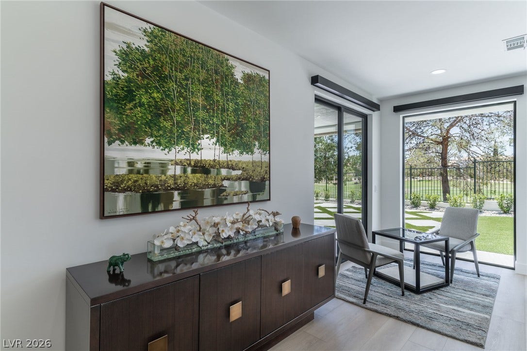 8633 Robinson Ridge Drive, Las Vegas, NV 89117 Glass sliding doors open from smooth hardwood flooring to a grassy backyard landscape.