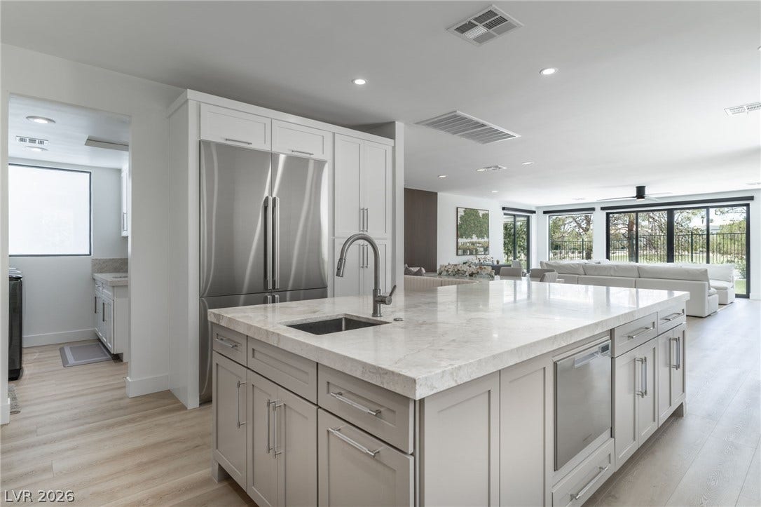 8633 Robinson Ridge Drive, Las Vegas, NV 89117 An expansive stone island anchors the modern kitchen, flowing seamlessly into the main living space.