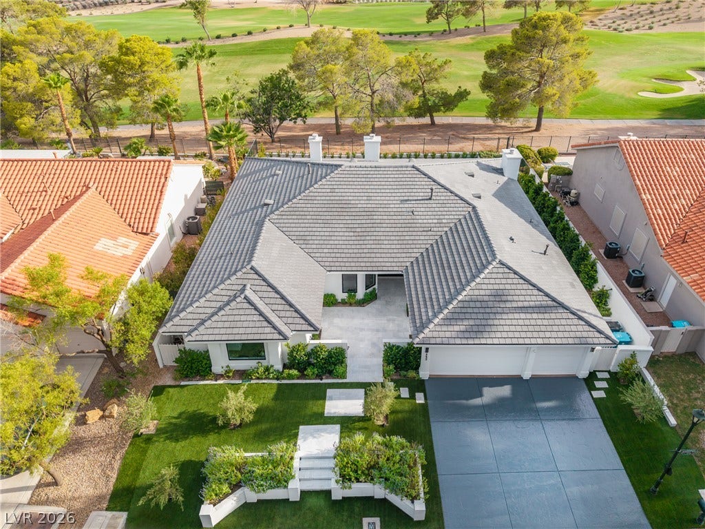 8633 Robinson Ridge Drive, Las Vegas, NV 89117 An aerial view showcases the tiled rooflines, manicured lawns, and adjacent golf course fairway greens.