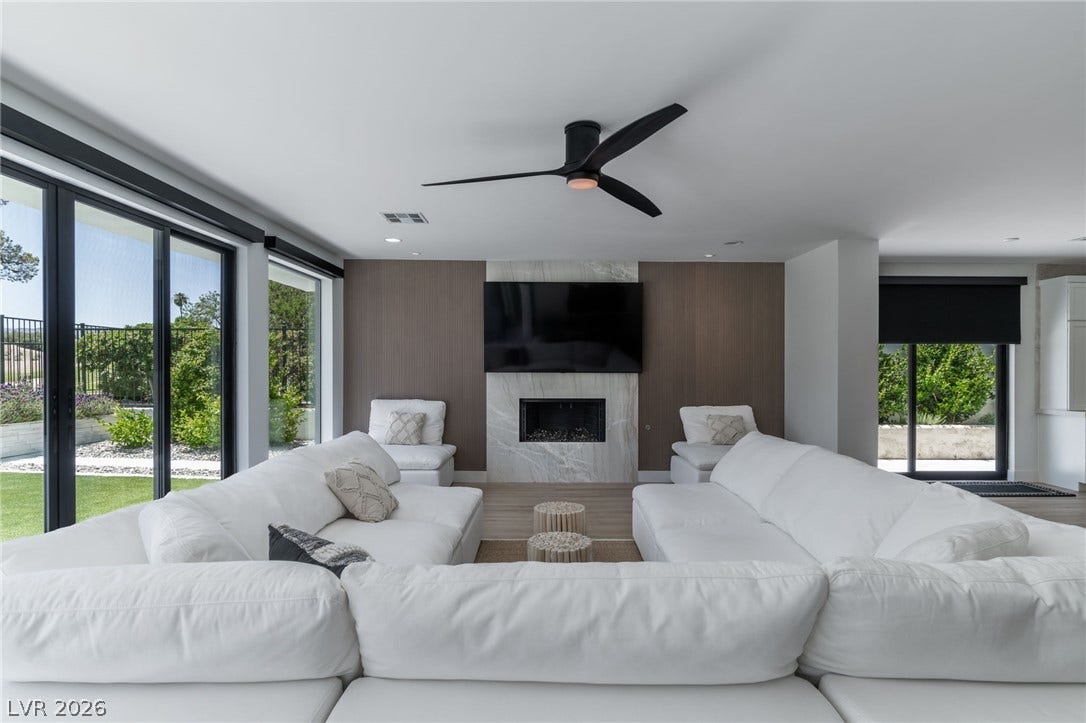 8633 Robinson Ridge Drive, Las Vegas, NV 89117 Gleaming wood floors and a contemporary fireplace define this open and airy living room space.