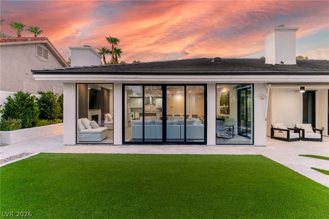 8633 Robinson Ridge Drive, Las Vegas, NV 89117 Sliding glass doors seamlessly connect modern indoor living areas to a manicured lawn.