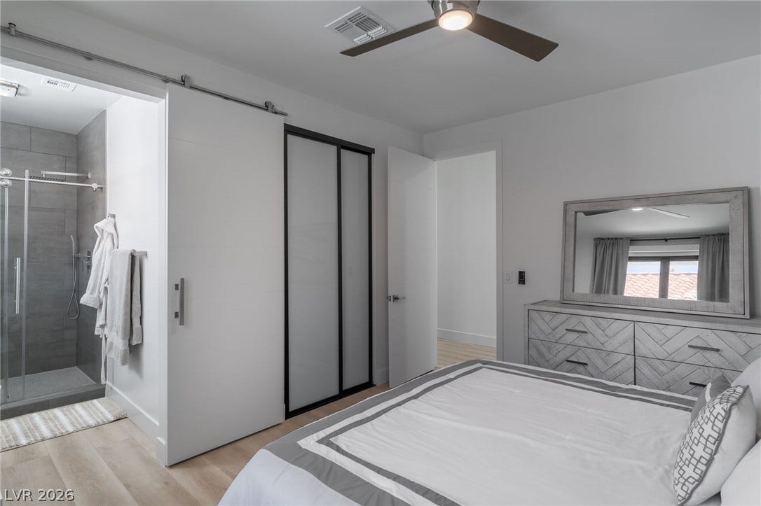 8633 Robinson Ridge Drive, Las Vegas, NV 89117 An integrated master suite showcases modern sliding doors and smooth wood-style flooring.