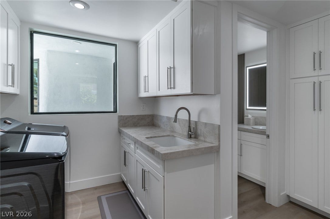 8633 Robinson Ridge Drive, Las Vegas, NV 89117 A functional laundry workspace boasts built-in cabinetry and stone countertops.