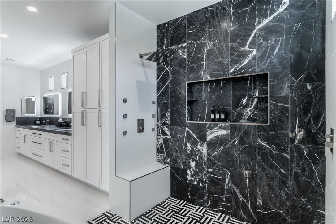 8633 Robinson Ridge Drive, Las Vegas, NV 89117 Dramatic dark marble tiling elevates this modern walk-in shower area.