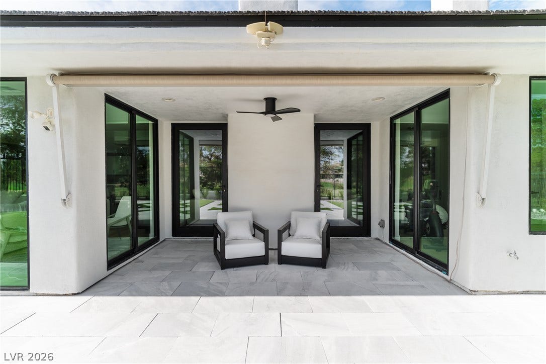 8633 Robinson Ridge Drive, Las Vegas, NV 89117 A covered patio with stone flooring connects seamlessly to the interior through glass sliding doors.