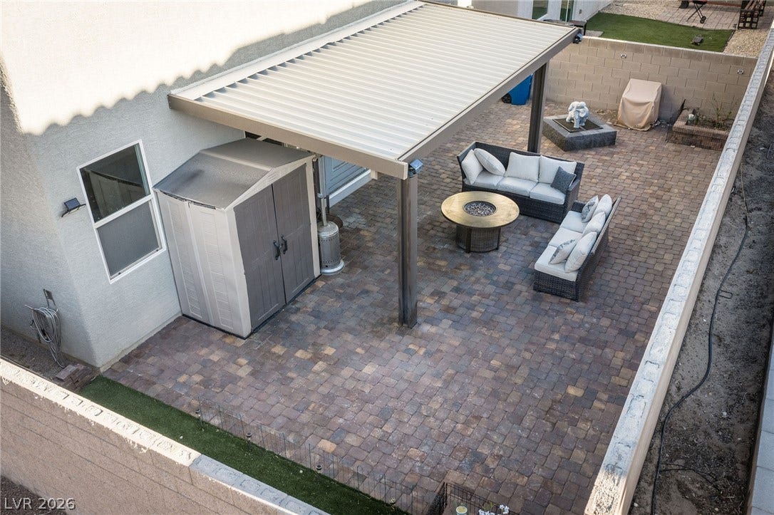 4605 Fragrant Street, North Las Vegas, NV 89031 An inviting backyard retreat showcases a paved patio covered by a large modern pergola.