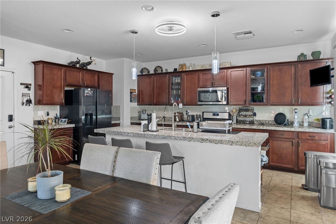 4605 Fragrant Street, North Las Vegas, NV 89031 Gleaming stone countertops and classic wood cabinetry enrich this spacious cooking and dining area.