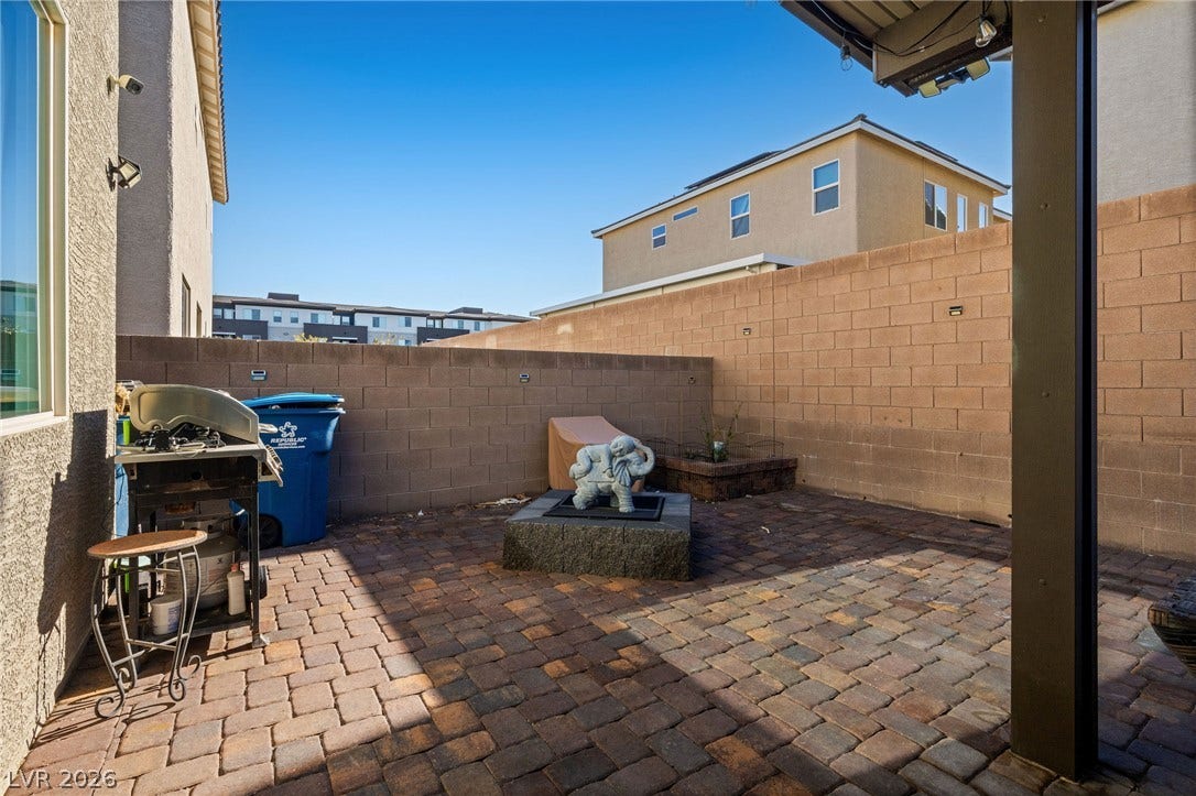 4605 Fragrant Street, North Las Vegas, NV 89031 An inviting paved patio is fully enclosed by tall block wall fencing under blue skies.