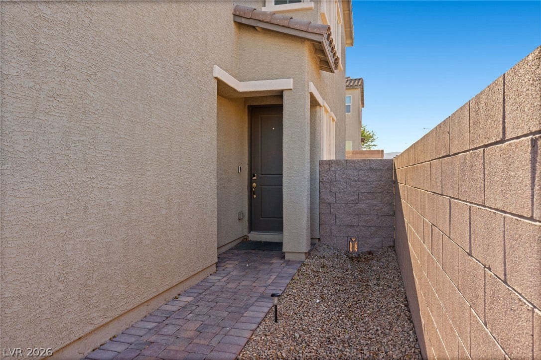 4605 Fragrant Street, North Las Vegas, NV 89031 A paved walkway leads past a block boundary wall to the private entrance.