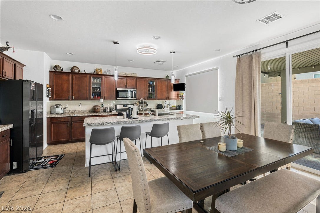 4605 Fragrant Street, North Las Vegas, NV 89031 Rich wood cabinetry and expansive granite countertops anchor this open concept dining space.