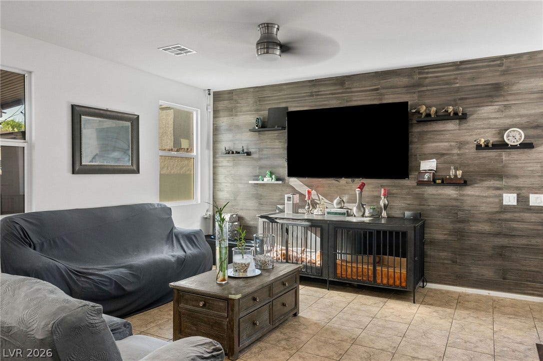 4605 Fragrant Street, North Las Vegas, NV 89031 Rich wood planking creates a striking accent wall in this tile-floored living area.