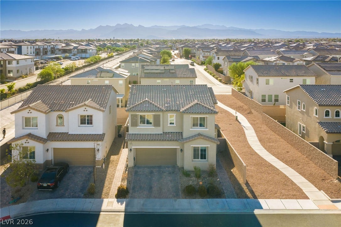 4605 Fragrant Street, North Las Vegas, NV 89031 Distant mountains frame this modern neighborhood filled with paved driveways and tiled roofs.