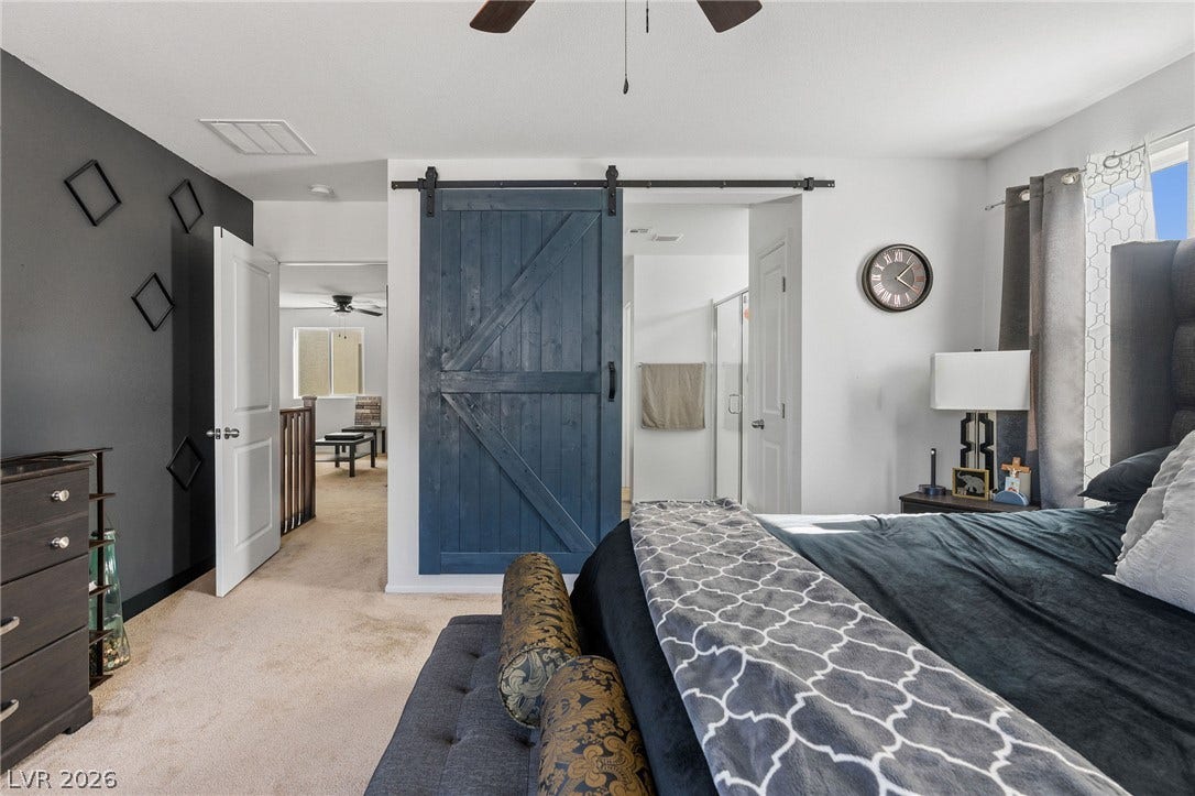 4605 Fragrant Street, North Las Vegas, NV 89031 Carpeted floors and a sliding barn door highlight this comfortable sleeping space.