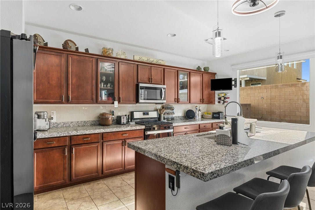 4605 Fragrant Street, North Las Vegas, NV 89031 Gleaming granite countertops pair with rich wood cabinetry and tile flooring in this kitchen.