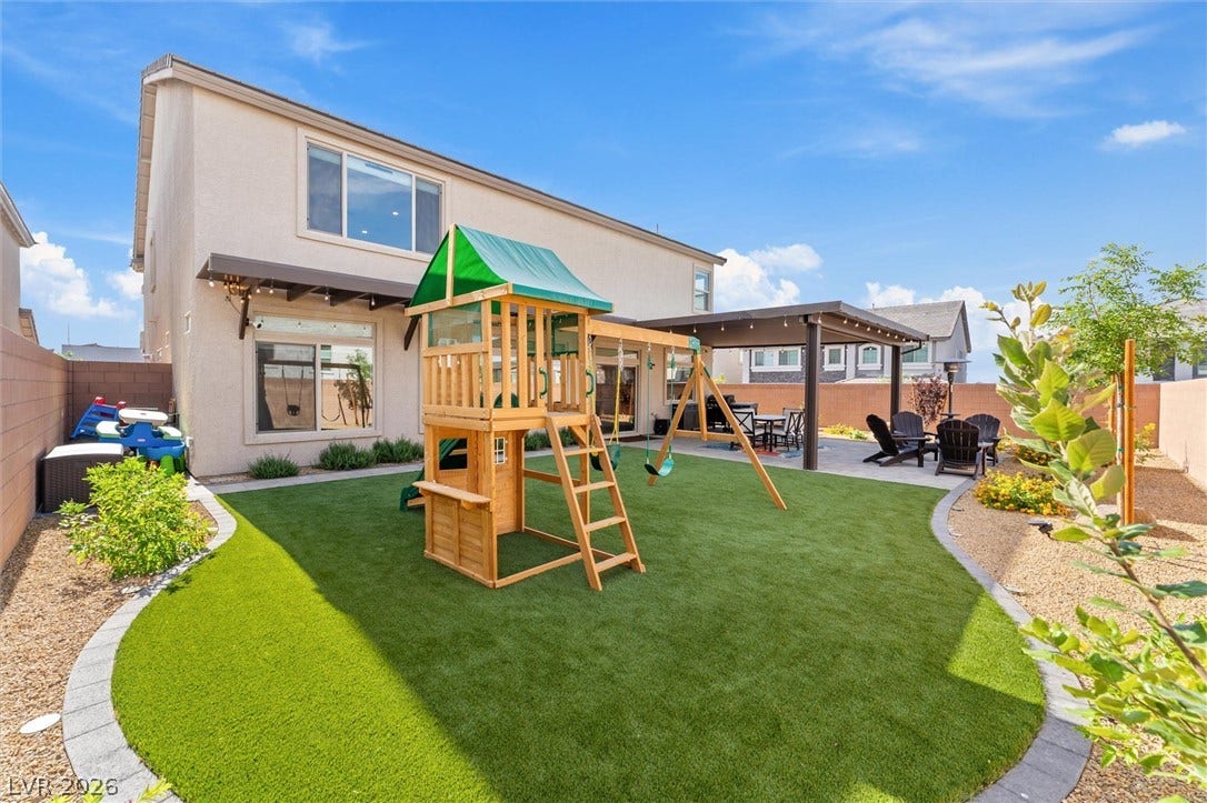 8724 Fortplaid Street, Las Vegas, NV 89139 An inviting backyard features a manicured lawn, paved patio area, and custom wooden pergola.