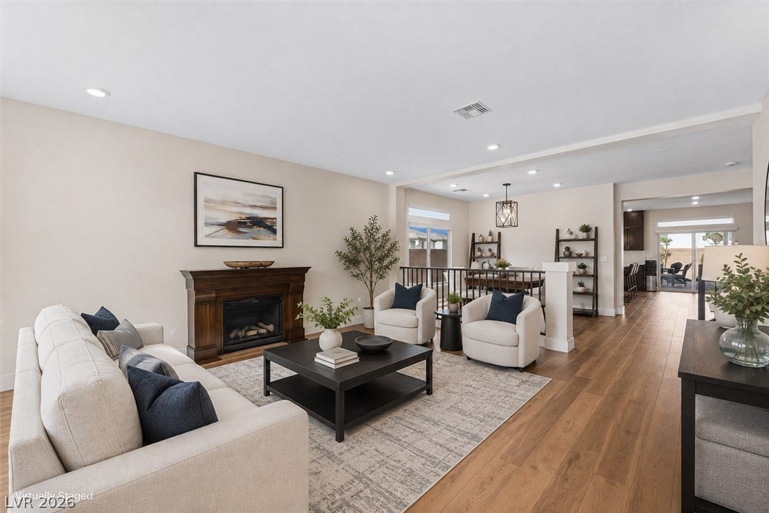 8724 Fortplaid Street, Las Vegas, NV 89139 Warm wood flooring and a classic fireplace anchor this open-concept layout.