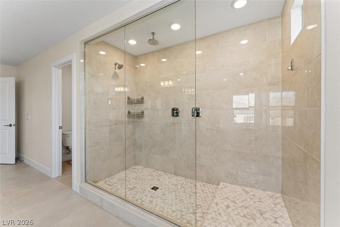 8724 Fortplaid Street, Las Vegas, NV 89139 Floor-to-ceiling tile surrounds a large walk-in shower with seamless glass doors.