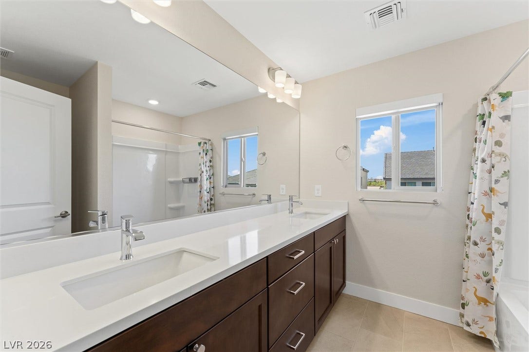 8724 Fortplaid Street, Las Vegas, NV 89139 Clean lines and a spacious dual vanity define this modern bathroom with natural light.