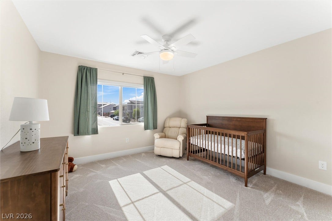 8724 Fortplaid Street, Las Vegas, NV 89139 A wide window illuminates this bedroom featuring plush carpet and smooth neutral walls.