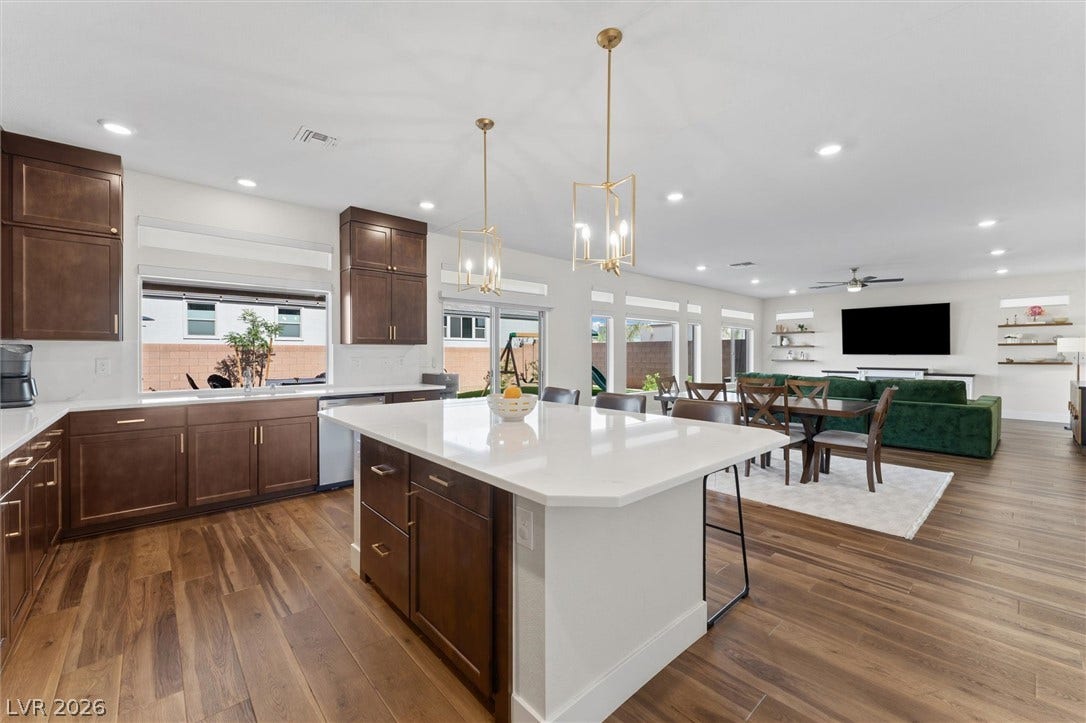 8724 Fortplaid Street, Las Vegas, NV 89139 Rich wood cabinetry contrasts beautifully with gleaming white countertops in an airy open-concept layout.