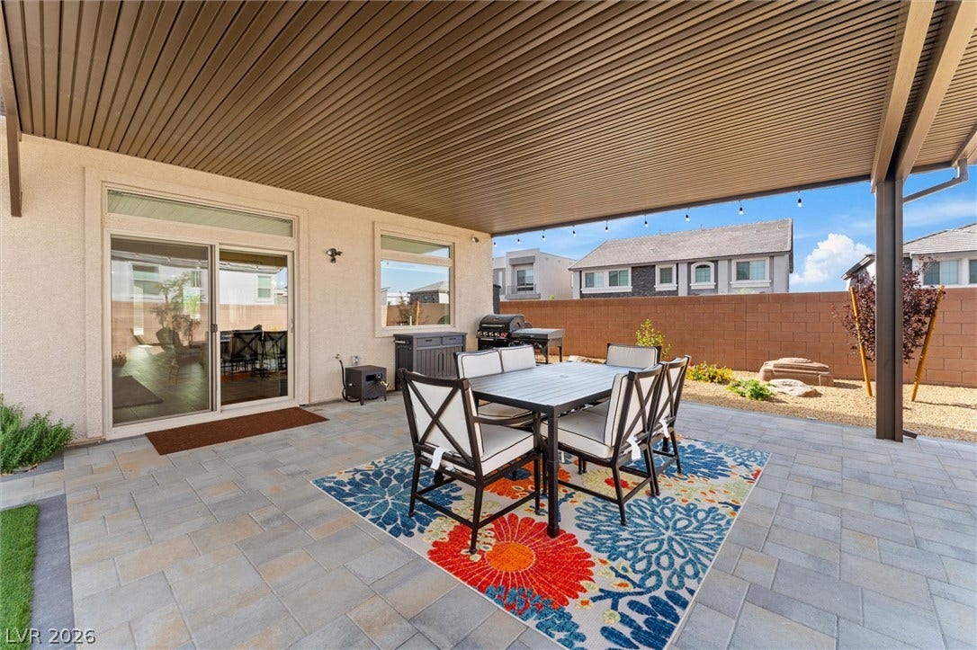 8724 Fortplaid Street, Las Vegas, NV 89139 A spacious covered patio features tiled pavers alongside sliding glass door entryways.