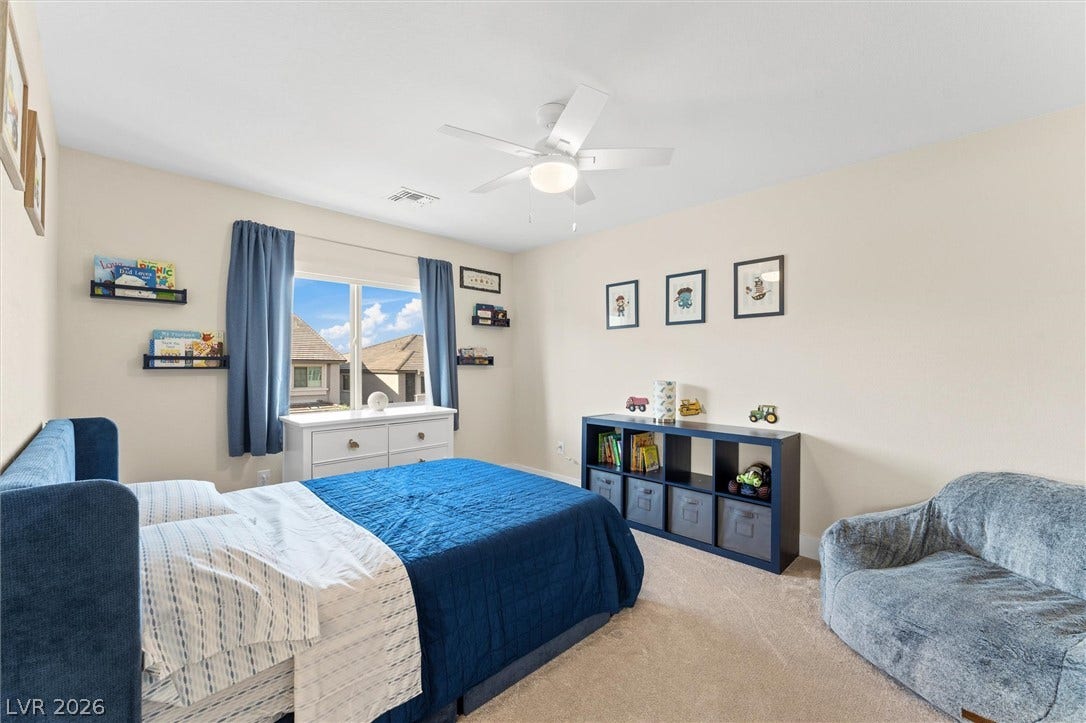 8724 Fortplaid Street, Las Vegas, NV 89139 A spacious secondary bedroom features plush carpet flooring and a wide window framing neighborhood views.