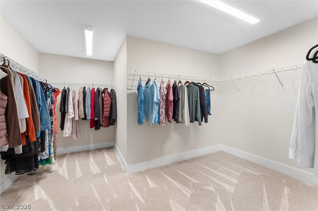 8724 Fortplaid Street, Las Vegas, NV 89139 Ample hanging space highlights this well-proportioned walk-in closet finished with neutral carpeting.