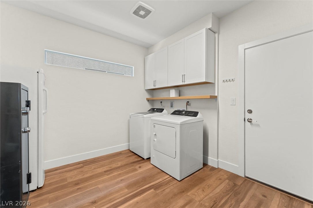8724 Fortplaid Street, Las Vegas, NV 89139 Streamlined laundry room features overhead cabinetry and resilient wood floors.