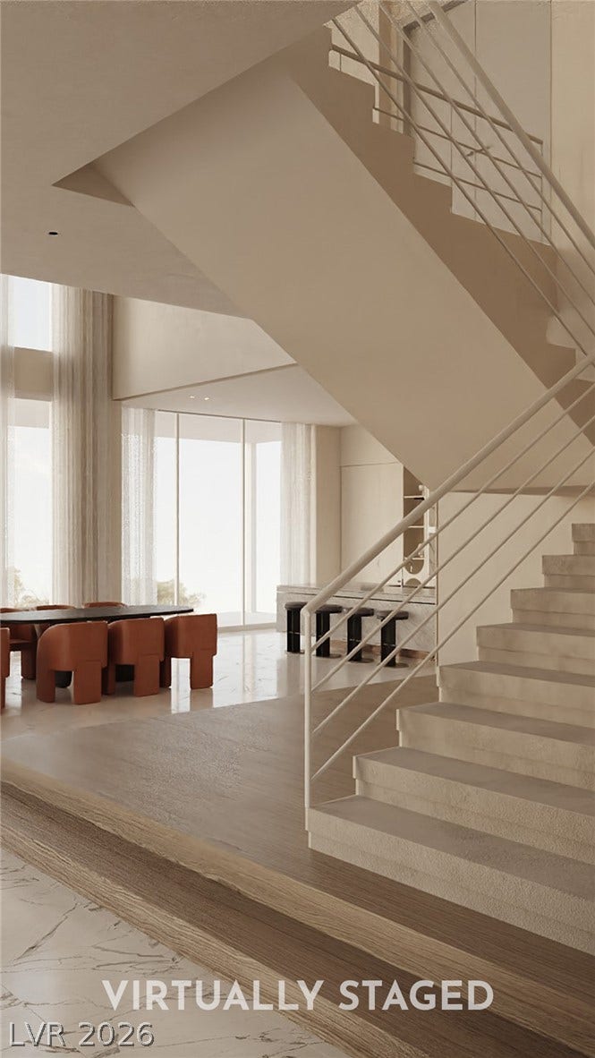 410 Net Zero Drive, Henderson, NV 89012 Dramatic architectural stairs descend into an open-concept living area lined with floor-to-ceiling windows.