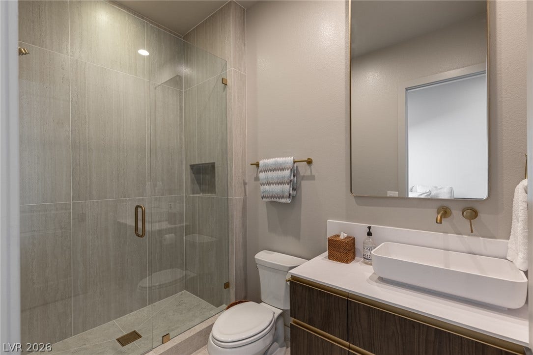 5216 Fading Sunset Drive, Las Vegas, NV 89135 A well-appointed bathroom features a spacious glass-enclosed shower and a sleek vanity with a modern basin.