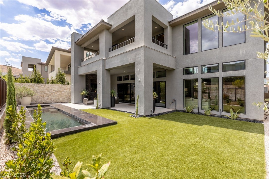 5216 Fading Sunset Drive, Las Vegas, NV 89135 A sleek modern exterior showcases abundant glass, clean lines, and an inviting backyard with a pristine pool.