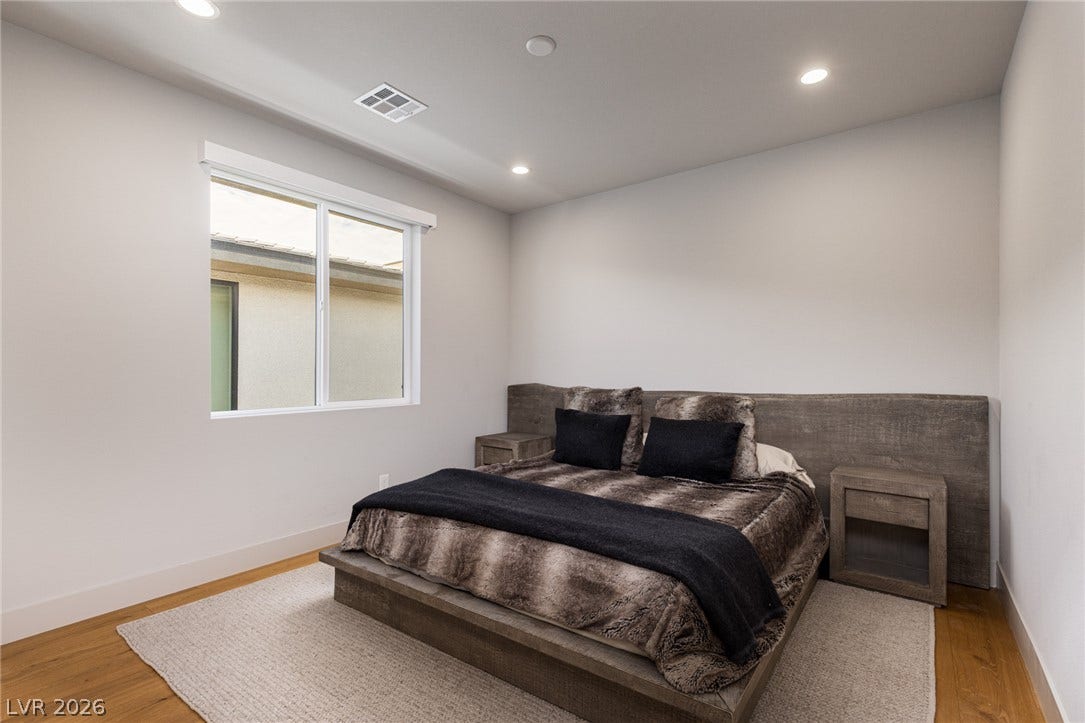 5216 Fading Sunset Drive, Las Vegas, NV 89135 Recessed lighting illuminates this well-appointed bedroom with hardwood flooring and a bright window.