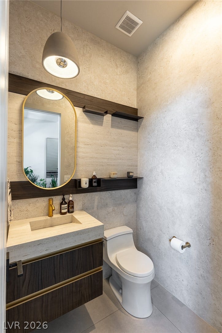 5216 Fading Sunset Drive, Las Vegas, NV 89135 A well-appointed powder room with stylish fixtures and warm lighting.