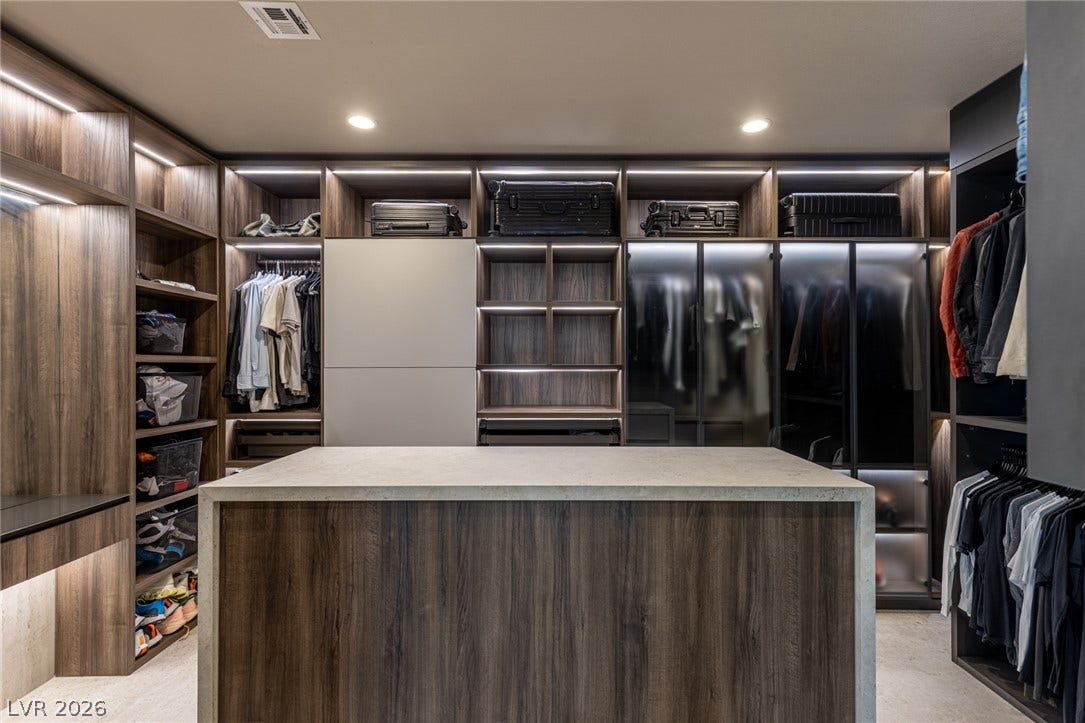 5216 Fading Sunset Drive, Las Vegas, NV 89135 Custom-designed closet system with illuminated shelving and a central island maximizes storage and style.