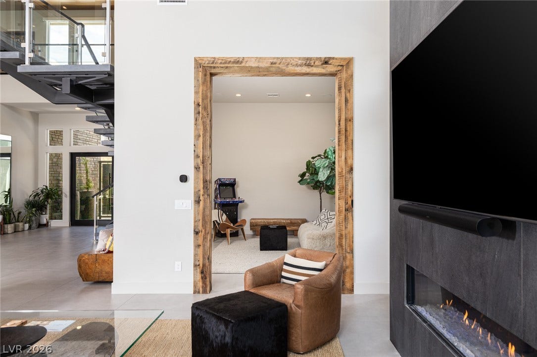5216 Fading Sunset Drive, Las Vegas, NV 89135 A striking modern fireplace with a large integrated television anchors this inviting living space.