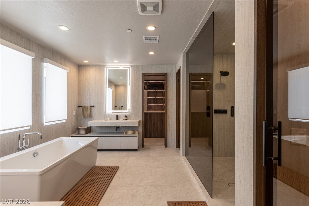5216 Fading Sunset Drive, Las Vegas, NV 89135 A refined bathroom featuring a sleek soaking tub and a spacious walk-in shower with clear glass.