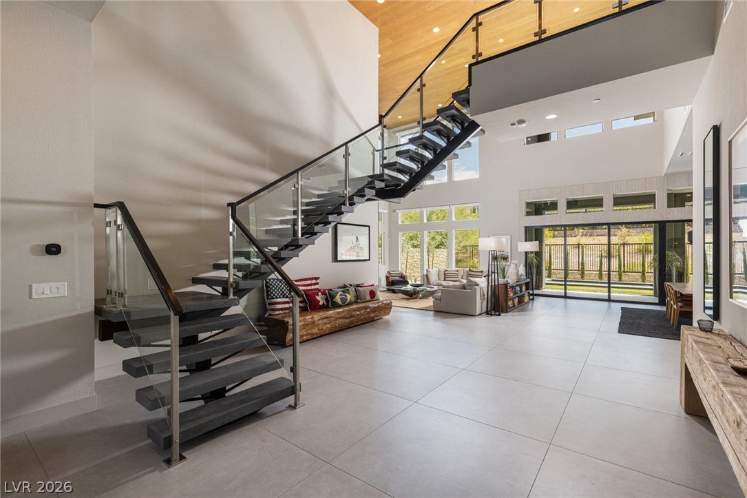 5216 Fading Sunset Drive, Las Vegas, NV 89135 A grand, modern staircase with glass railings anchors this luminous, open-concept living space.