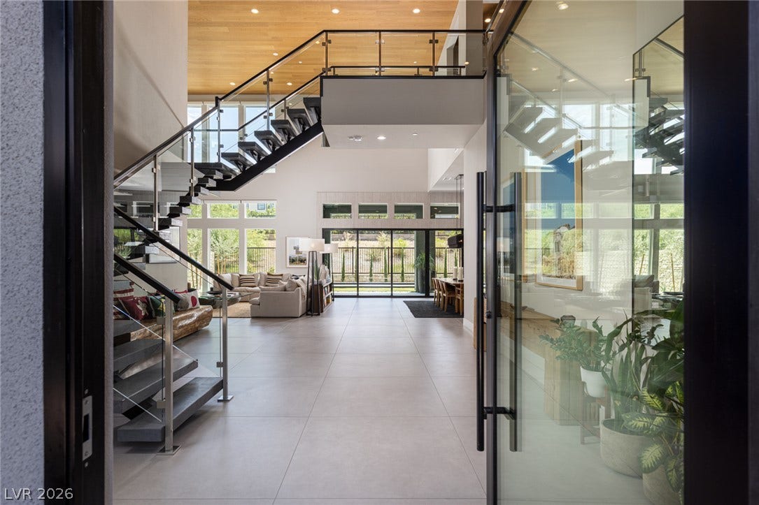 5216 Fading Sunset Drive, Las Vegas, NV 89135 An open entryway flows past a modern floating staircase into the luminous main living area.