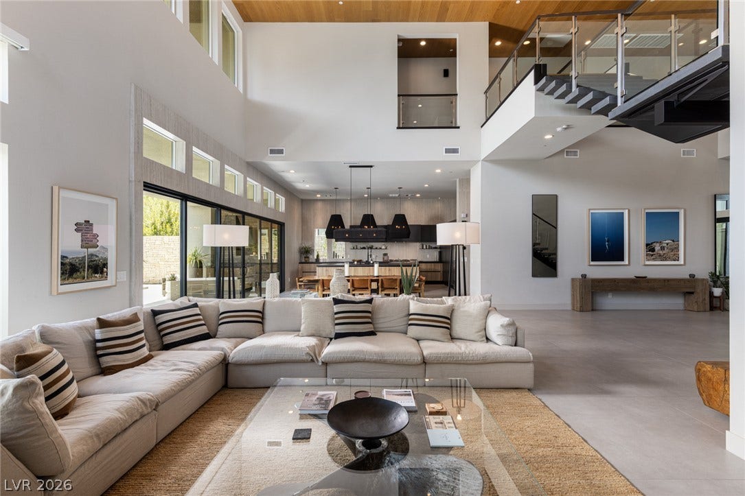 5216 Fading Sunset Drive, Las Vegas, NV 89135 Towering ceilings and wood paneling crown an expansive, light-filled contemporary living space.
