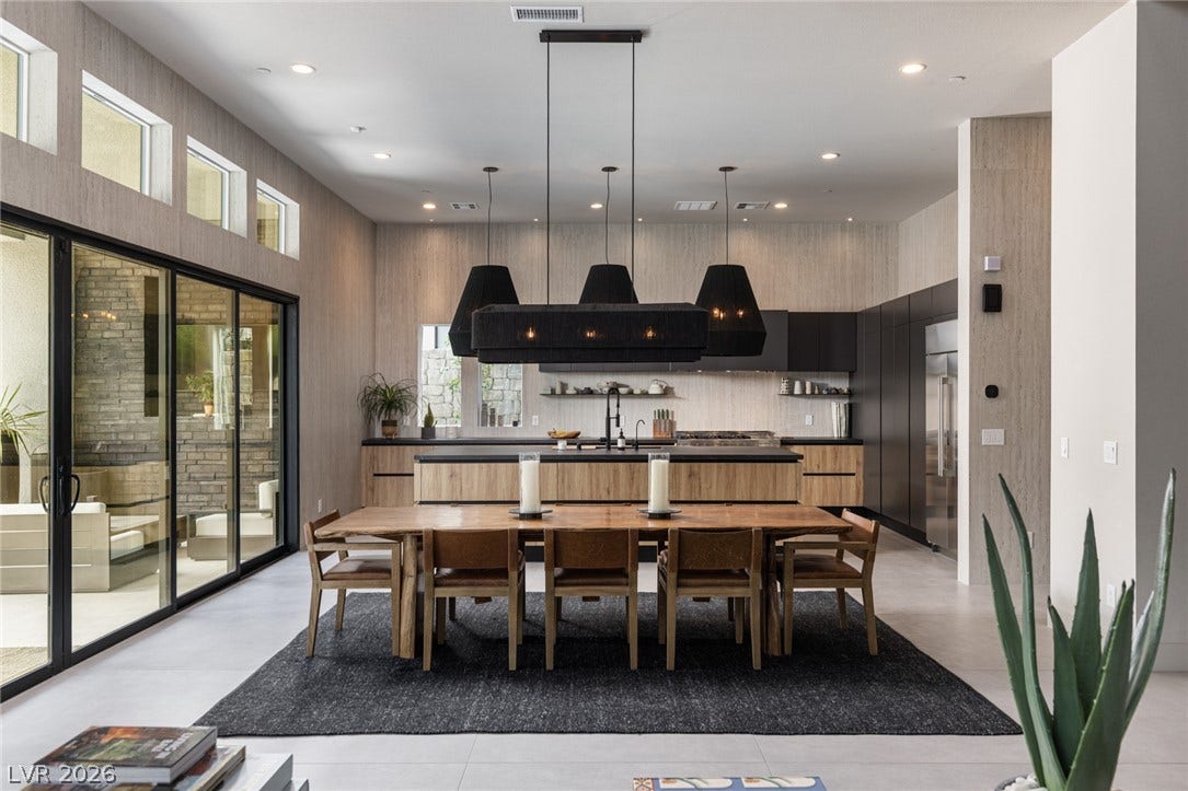 5216 Fading Sunset Drive, Las Vegas, NV 89135 Soaring ceilings and glass sliding doors enhance this open dining and kitchen area.