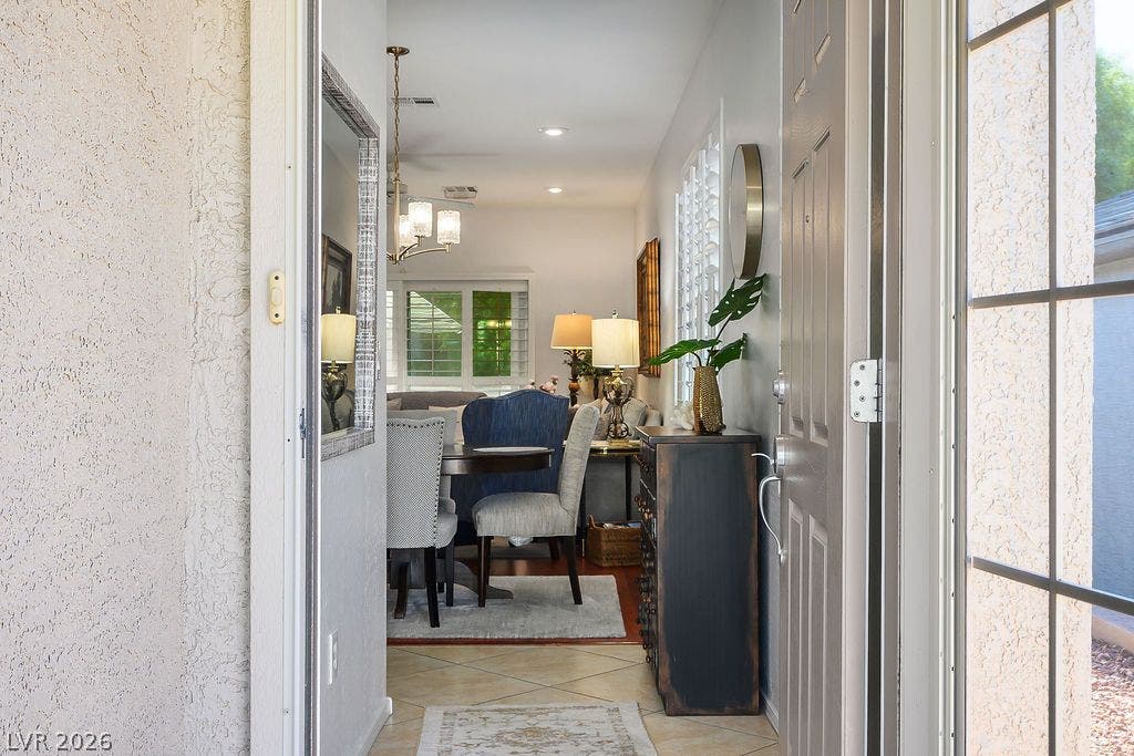 An inviting entryway opens directly into a bright dining and living space with tiled flooring.